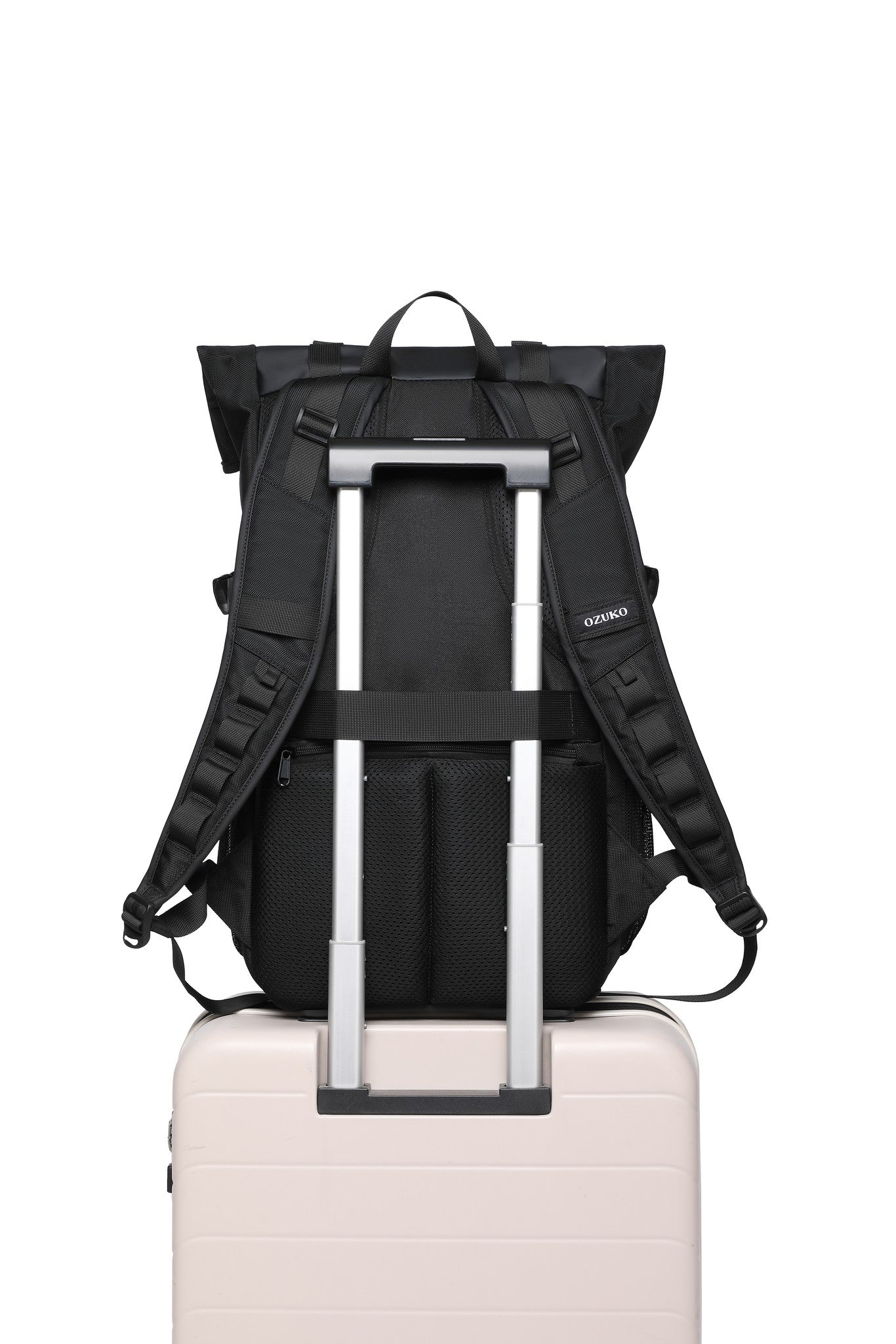 Summit Backpack 25L in Black, mounted on a rolling suitcase handle via the rear luggage pass-through strap