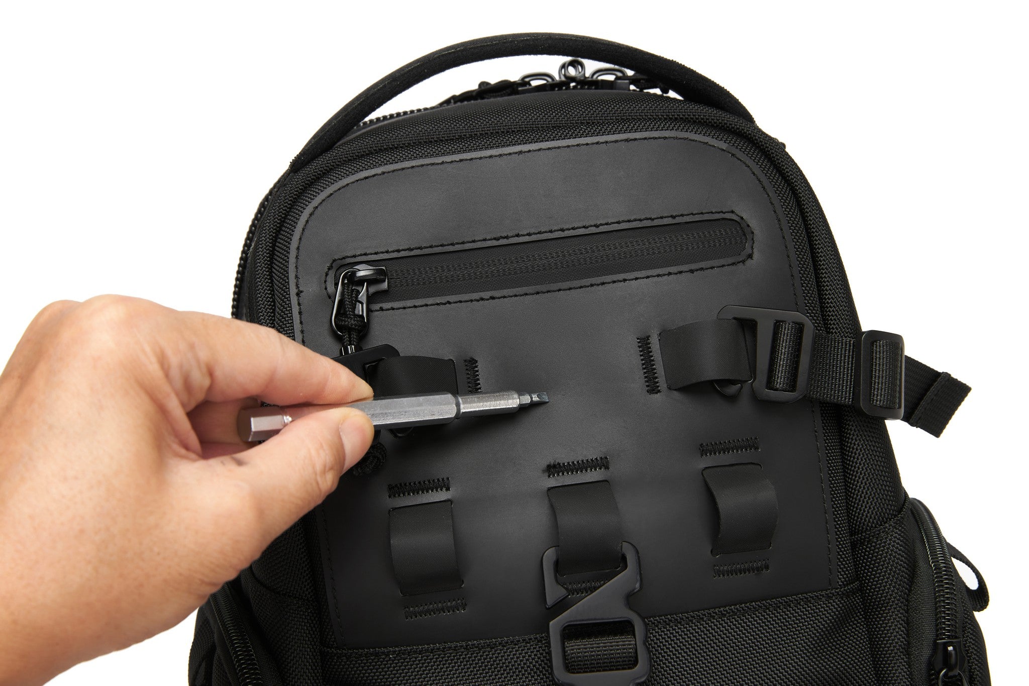 Ridge Sling Backpack 12L in Black - close-up of a hand securing the front clip-buckle strap