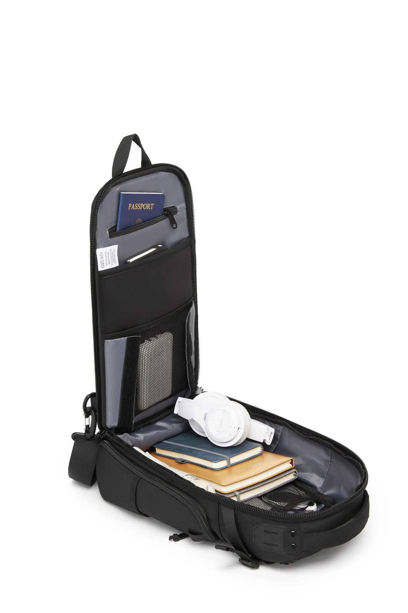 Ridge Sling Backpack 12L in Black - open side view showing the interior organizer panel holding a passport, notebook, and headphones