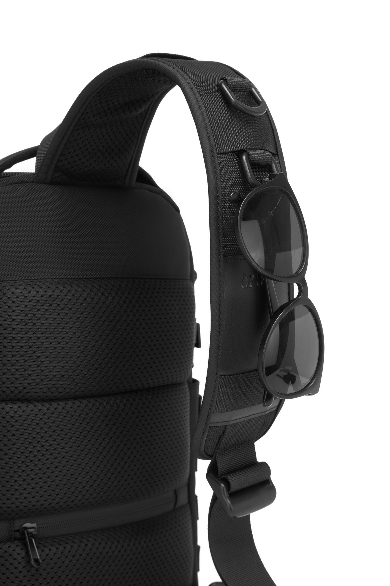 Daytrip Backpack 12L in Black - side view showing the MOLLE webbing and adjustable sling strap