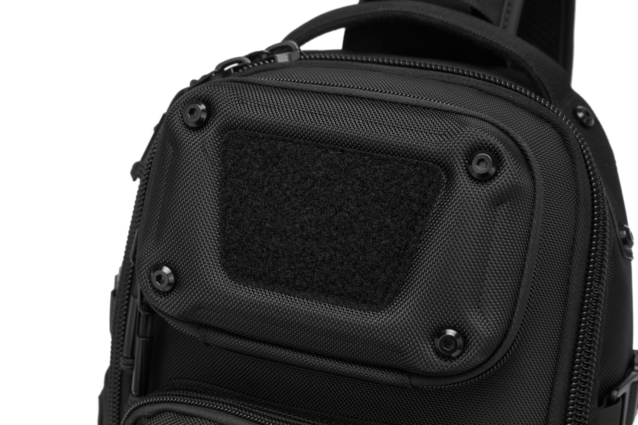 Daytrip Backpack 12L in Black - close-up of the hard-shell top pocket with its molded velcro ID panel