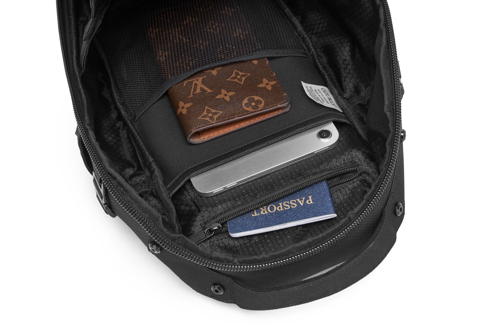 Daytrip Backpack 12L in Black - top-down view of the interior lid pocket holding a wallet, phone, and passport