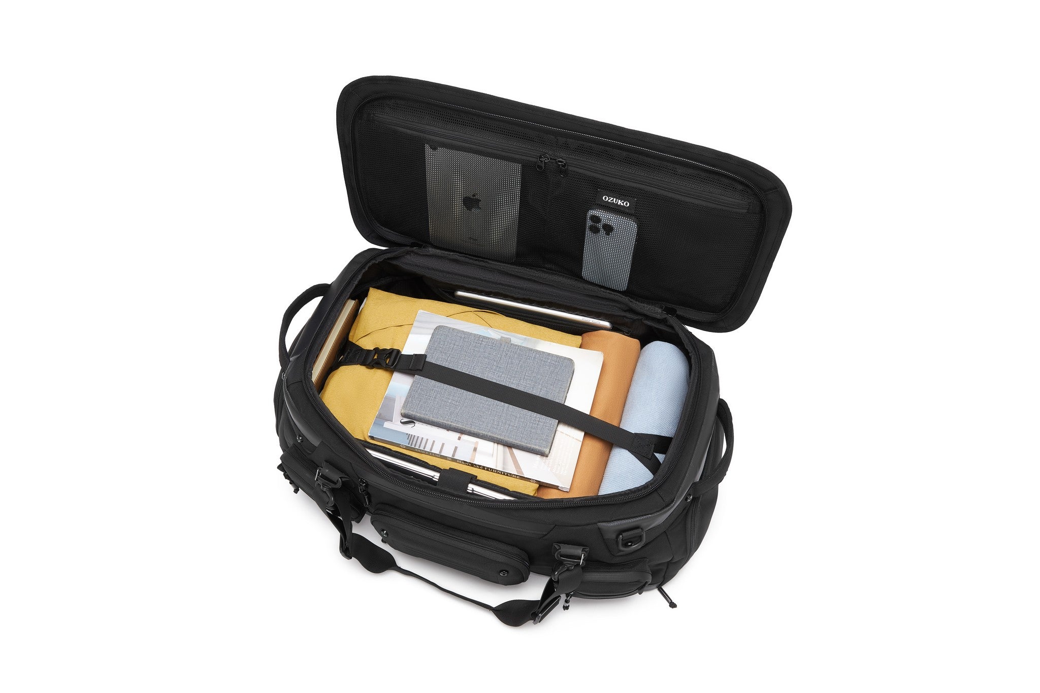 Oono Voyager Duffel 50L in black, open main compartment packed with clothing, a notebook, and a tablet, with a mesh phone pocket in the lid