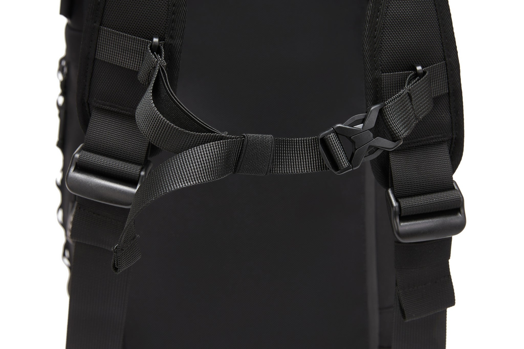 Close-up of the sternum strap buckle connecting the padded backpack straps