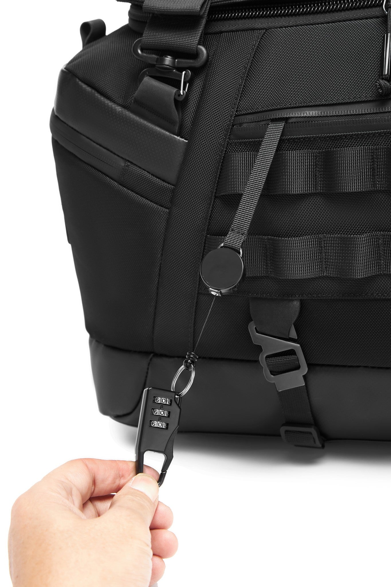 Close-up of the side carry handle and MOLLE webbing, with a retractable key leash clipped to a D-ring