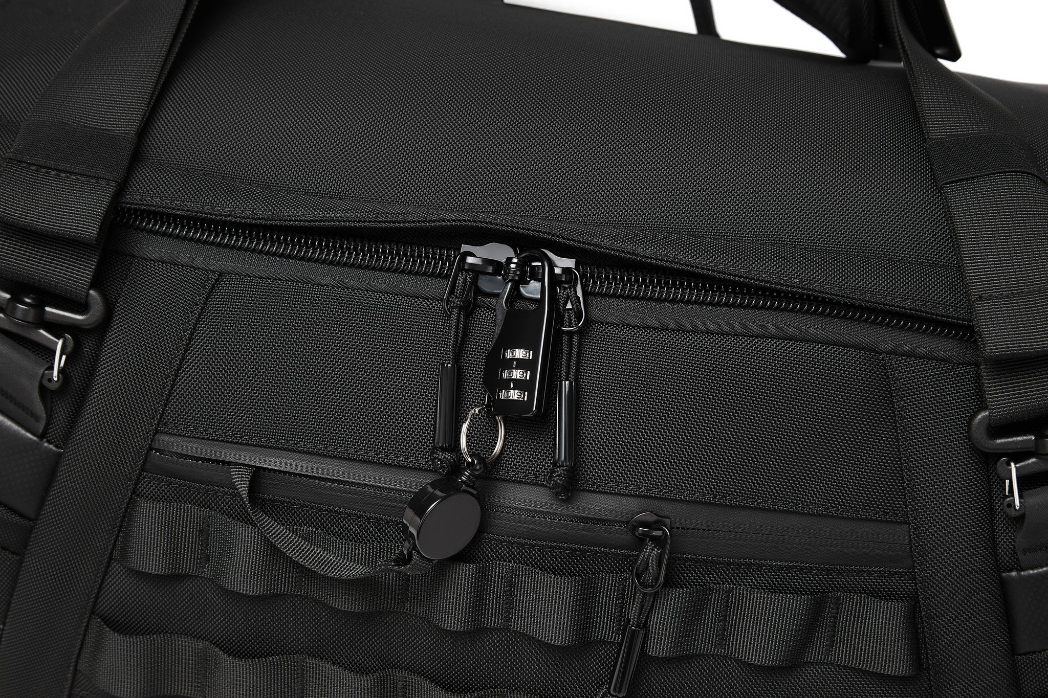 Close-up of the built-in 3-digit combination lock securing the main zipper, with MOLLE webbing across the front panel